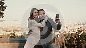 Young beautiful couple take the selfie photo against the panorama of Rome, Italy. Happy man kisses woman and hugs.