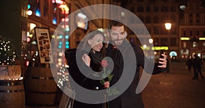 Young beautiful couple taking selfie in a city at night.