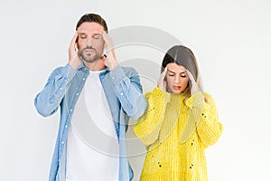 Young beautiful couple togheter over isolated background with hand on head for pain in head because stress