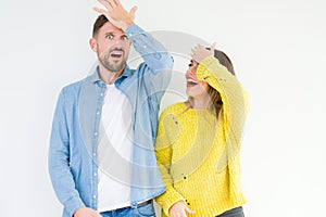 Young beautiful couple togheter over isolated background surprised with hand on head for mistake, remember error