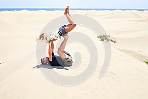 Young beautiful couple trainning acroyoga at the beach