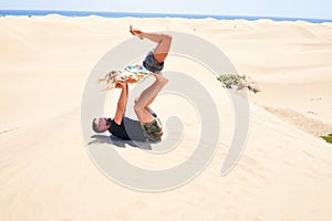 Young beautiful couple trainning acroyoga at the beach