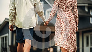 Young Beautiful Couple Walking Outdoors Towards the Country House, Holding Hands. Y
