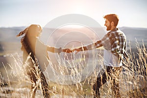 Young beautiful couple walking outside on beautiful sunset. Perfect romantic landscape for lovestory.