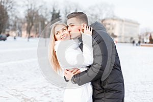 Young beautiful couple in the winter cold day walking in the cit