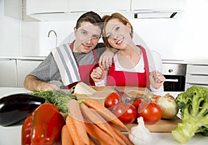 Young beautiful couple working at home kitchen preparing vegetable salad together smiling happy