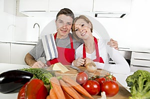 Young beautiful couple working at home kitchen preparing vegetable salad together smiling happy