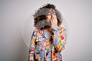 Young beautiful curly arab woman wearing floral colorful shirt standing over white background looking stressed and nervous with