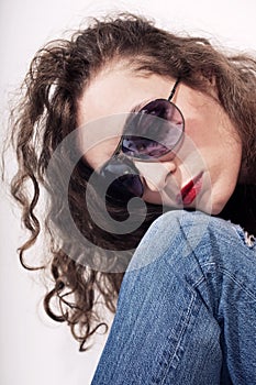 Young beautiful curly woman in sunglasses