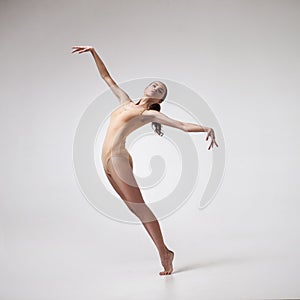 Young beautiful dancer in beige swimsuit