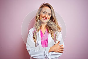 Young beautiful doctor woman using stethoscope over pink  background happy face smiling with crossed arms looking at the