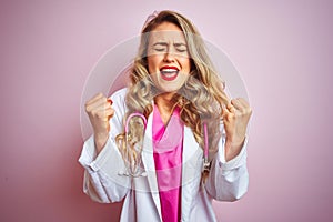 Young beautiful doctor woman using stethoscope over pink isolated background excited for success with arms raised and eyes closed