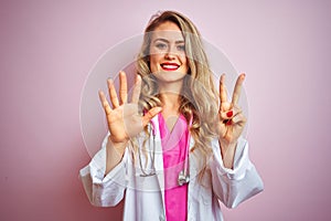 Young beautiful doctor woman using stethoscope over pink isolated background showing and pointing up with fingers number seven