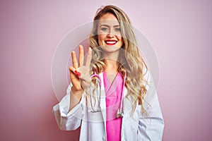 Young beautiful doctor woman using stethoscope over pink isolated background showing and pointing up with fingers number three