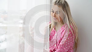 Young beautiful dreamy thoughtful girl window