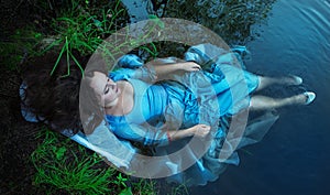 Young beautiful drowned woman lying in the water photo