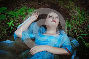 Young beautiful drowned woman lying in the water photo