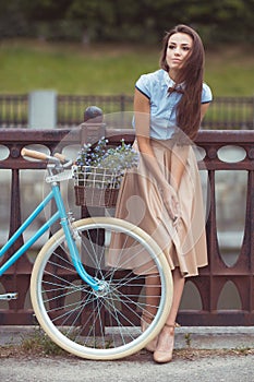 Young beautiful, elegantly dressed woman with bicycle