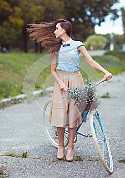 Young beautiful, elegantly dressed woman with bicycle