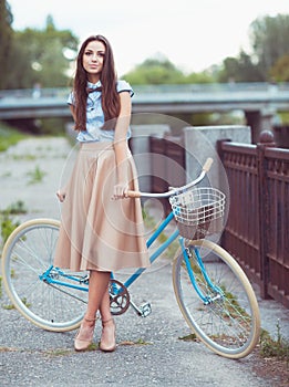 Young beautiful, elegantly dressed woman with bicycle