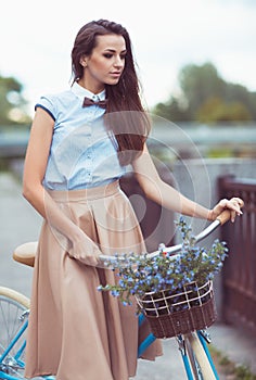 Young beautiful, elegantly dressed woman with bicycle