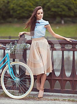 Young beautiful, elegantly dressed woman with bicycle