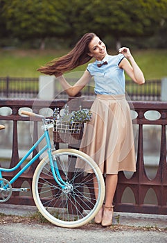 Young beautiful, elegantly dressed woman with bicycle