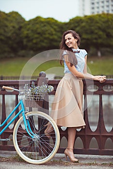 Young beautiful, elegantly dressed woman with bicycle