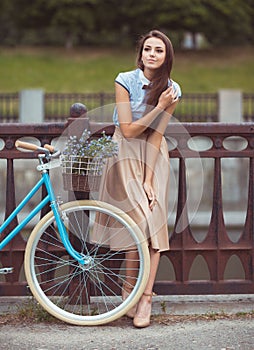 Young beautiful, elegantly dressed woman with bicycle