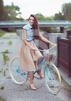 Young beautiful, elegantly dressed woman with bicycle