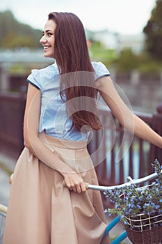 Young beautiful, elegantly dressed woman with bicycle