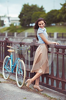 Young beautiful, elegantly dressed woman with bicycle