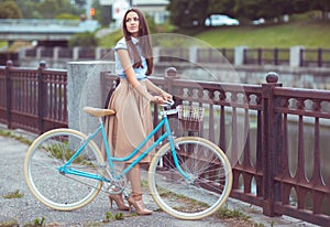 Young beautiful, elegantly dressed woman with bicycle