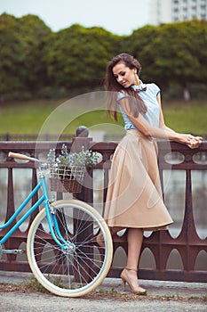 Young beautiful, elegantly dressed woman with bicycle