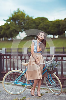 Young beautiful, elegantly dressed woman with bicycle