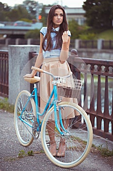 Young beautiful, elegantly dressed woman with bicycle