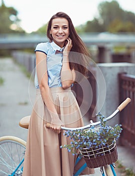 Young beautiful, elegantly dressed woman with bicycle