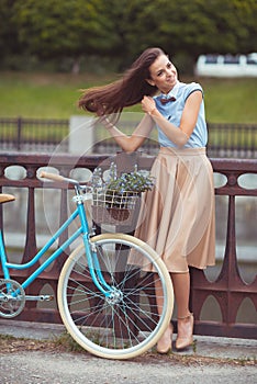 Young beautiful, elegantly dressed woman with bicycle