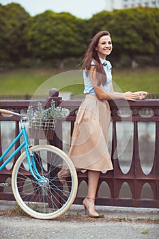 Young beautiful, elegantly dressed woman with bicycle