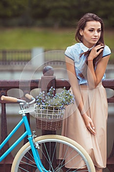 Young beautiful, elegantly dressed woman with bicycle