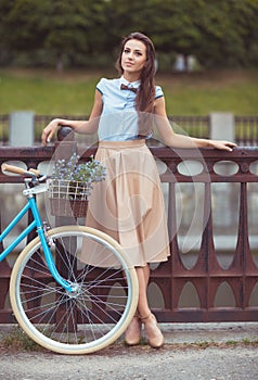 Young beautiful, elegantly dressed woman with bicycle