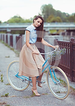 Young beautiful, elegantly dressed woman with bicycle