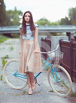 Young beautiful, elegantly dressed woman with bicycle