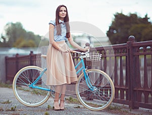 Young beautiful, elegantly dressed woman with bicycle