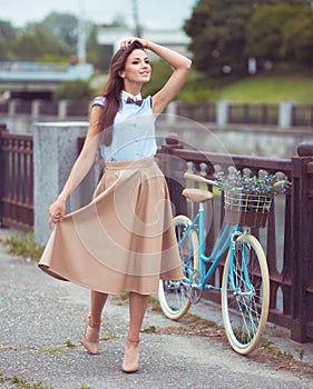 Young beautiful, elegantly dressed woman with bicycle