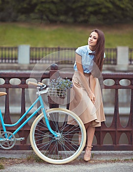 Young beautiful, elegantly dressed woman with bicycle