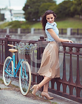 Young beautiful, elegantly dressed woman with bicycle