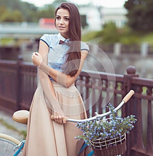 Young beautiful, elegantly dressed woman with bicycle