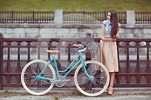 Young beautiful, elegantly dressed woman with bicycle, summer an