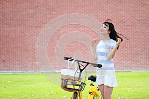 Young beautiful, elegantly dressed woman with Sharing bicycle. Beauty, fashion and lifestyle